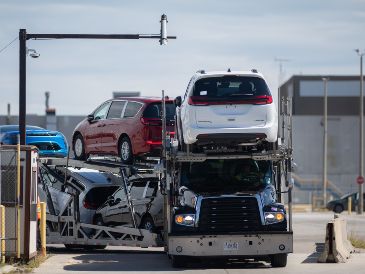 Un camión de transporte que lleva Chrysler Pacificas sale de la planta de ensamblaje de Windsor, en Ontario, Canadá. AP/D. Melmer