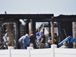 Investigadores trabajan en el sitio donde una familia fue asesinada y la casa incendiada, en Billings, Montana. AP/M. Brown