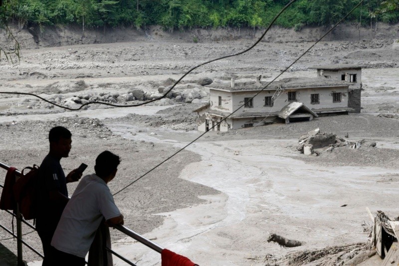Varias personas observan cómo las aguas de la inundación arrasan Trishuli Bazar tras una crecida repentina, en el distrito de Nuwakot, Nepal. EFE/EPA/NARENDRA SHRESTHA&nbsp;
