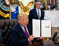 El presidente Trump muestra la firma que convierte al lago Ontario en lago América. EFE / EPA / AL DRAGO / POOL