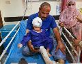 Un hombre acompaña a un niño que, según la prensa iraní, resultó herido en el ataque a una vivienda donde se celebraba una boda en la provincia de Kuhestak. AP/R. Poudat