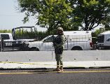 Un agente de la Policía Federal permanece junto a vehículos policiales cerca del lugar donde se halló el cuerpo del diputado Zenyazen Escobar García. AFP/V. Razo