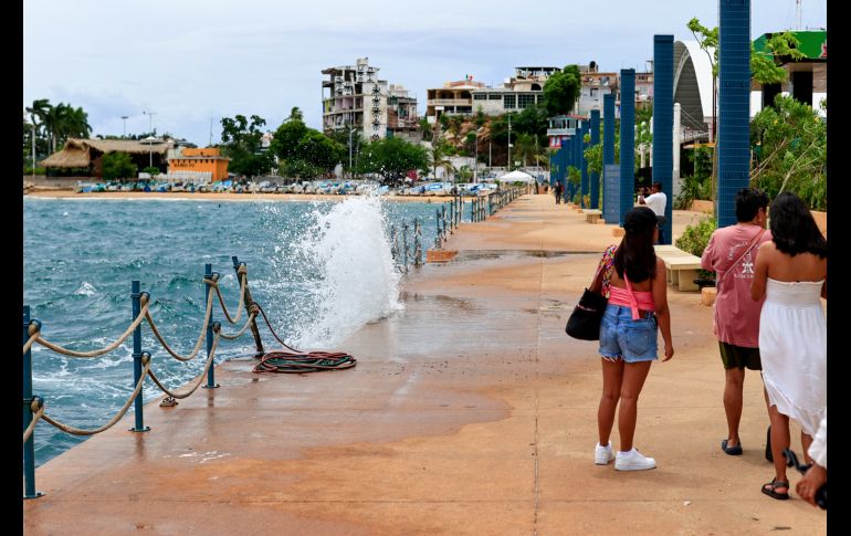 Personas caminan por el malecón con fuerte oleaje ante el paso del huracán 'Polo' este martes en Acapulco. EFE/D. Guzmán