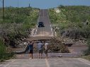 Varios hombres inspeccionan una carretera dañada por la crecida de un río a lo largo de la ruta hacia Las Barrancas, en Baja California Sur. AP/E. Verdugo