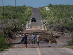 Varios hombres inspeccionan una carretera dañada por la crecida de un río a lo largo de la ruta hacia Las Barrancas, en Baja California Sur. AP/E. Verdugo