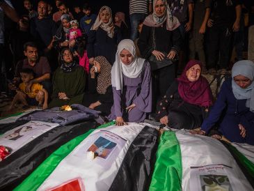 Los dolientes encienden velas durante un funeral colectivo y una vigilia en memoria de 105 palestinos cerca de los escombros del edificio Al Tajj en la Ciudad de Gaza, Franja de Gaza, el 30 de septiembre de 2026.EFE/M. Saber