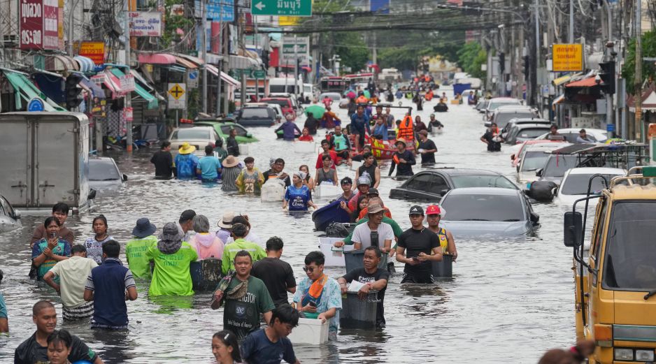 Personas caminan por una calle inundada tras fuertes lluvias en Bangkok, Tailandia. AP/S. Lalit