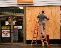 Jason Coffey coloca tablones en una tienda en una gasolinera mientras el huracán Isaías se acerca a Pensacola Beach, Florida. AP/G. Herbert