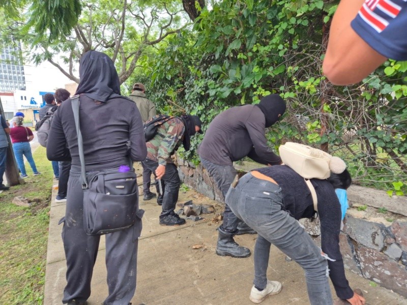 Manifestantes recogen piedras para lanzarlas&nbsp;contra policías en medio de los enfrentamientos. EL INFORMADOR / R. Bobadilla