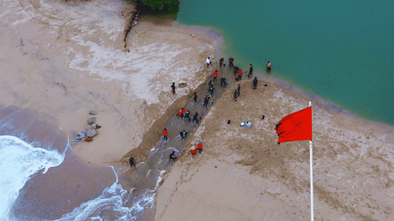 El personal municipal realiza trabajos de desazolve manual para liberar el flujo del agua acumulada, mitigar riesgos y prevenir posibles daños por erosión en la infraestructura aledaña al cauce. ESPECIAL / Protección Civil y Bomberos Puerto Vallarta