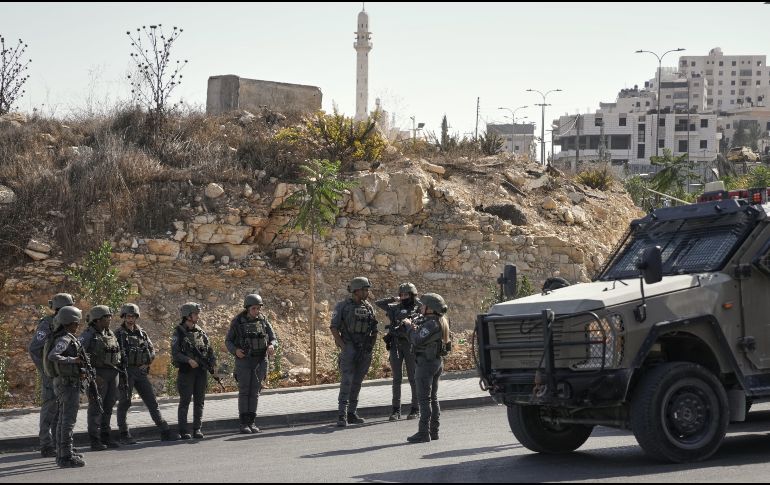Soldados israelíes se reúnen en el lugar de un ataque a tiros perpetrado por hombres armados palestinos en un cruce cerca de Hebrón, en la Cisjordania ocupada. AP/M. Illean