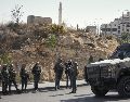 Soldados israelíes se reúnen en el lugar de un ataque a tiros perpetrado por hombres armados palestinos en un cruce cerca de Hebrón, en la Cisjordania ocupada. AP/M. Illean