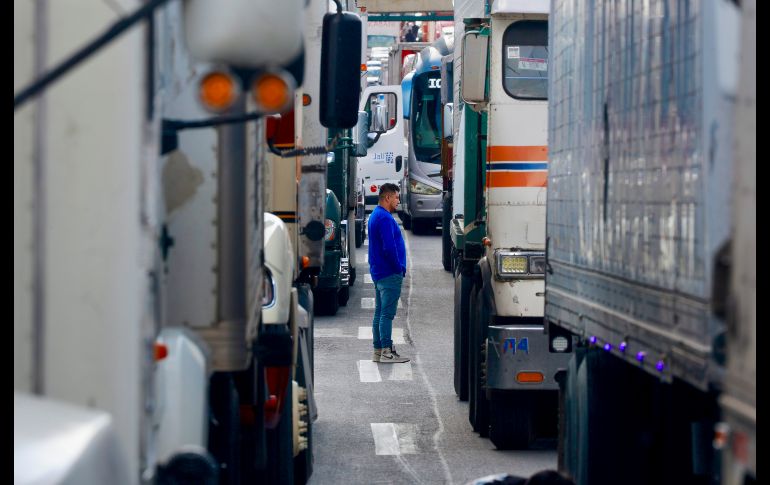 Un hombre camina entre los camiones que mantienen un bloqueo carretero durante una manifestación de transportistas, este lunes, en Toluca. EFE/F. Gutiérrez