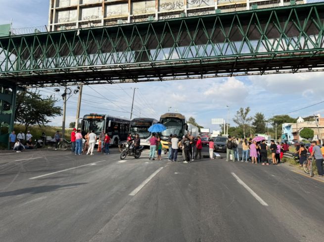 Al menos una decena de personas bloqueó este martes tres carriles de la Carretera a Chapala con pancartas en mano, llantas, tierra y sillas. EL INFORMADOR