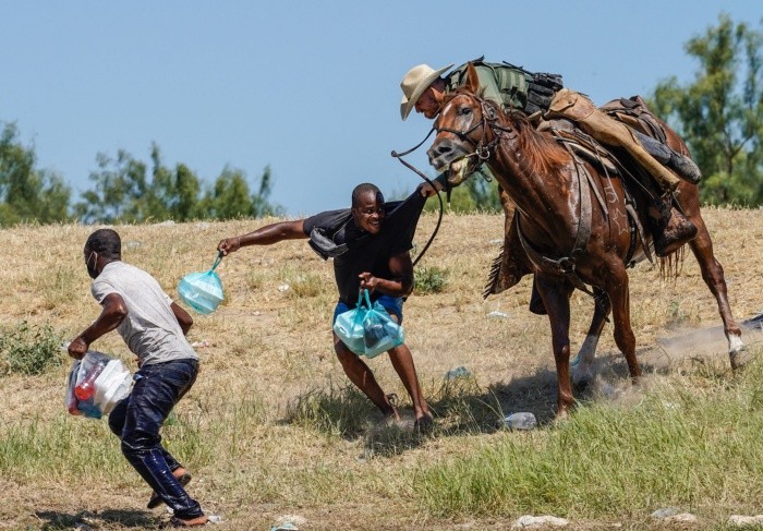 A United States Border Patrol agent on horseback tries to stop a Haitian migrant from entering an encampment on the banks of the Rio Grande near the Acuna Del Rio International Bridge in Del Rio, Texas on September 19, 2021. The United States said Saturday it would ramp up deportation flights for thousands of migrants who flooded into the Texas border city of Del Rio, as authorities scramble to alleviate a burgeoning crisis for President Joe Biden's administration. (Photo by PAUL RATJE / AFP)
